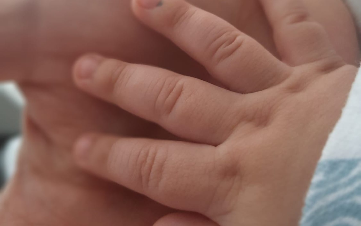 Mano de un bebé sobre la mano de su mamá